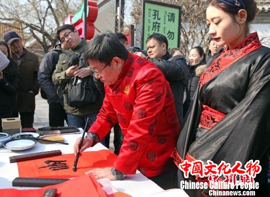 贴春联、做年画，山东曲阜孔府“洋溢”独特年味。图为孔子第七十五代孙、孔子书画院名誉院长孔祥胜正在现场书写孔府的“专属”春联。　陈硕 摄