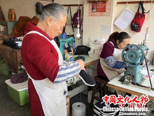 非物质文化遗产“唐昌布鞋”的传承人赖淑芳仔细检查半成品质量。　吴平华 摄