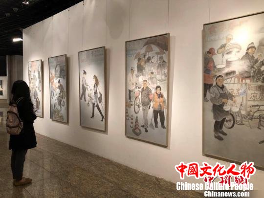 图为观众驻足观看《三好街的故事》组画。　尹力 摄