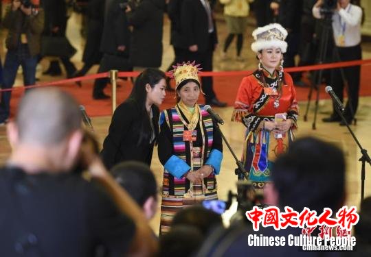 3月11日，十三届全国人大一次会议在北京人民大会堂举行第三场“代表通道”集中采访活动。图为全国人大代表、西藏自治区隆子县玉麦乡玉麦村村务监督委员会主任卓嘎(中)在藏语翻译的帮助下接受采访。<a target='_blank'  data-cke-saved-href='http://www.chinanews.com/' href='http://www.chinanews.com/'>中新社</a>记者 侯宇 摄