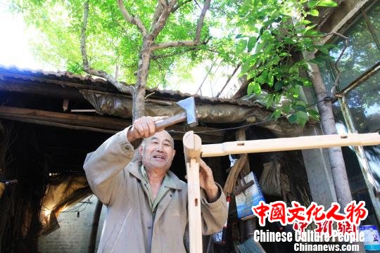 图为徐光祥展示榫卯结构组合方式。 郝学娟 摄 图为徐光祥展示榫卯结构组合方式。 郝学娟 摄