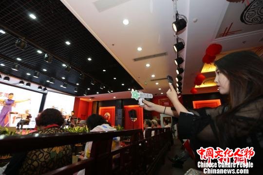 非遗传播新手段——曲艺进社区展演活动现场，一位女主播在进行网络直播。　张道正 摄