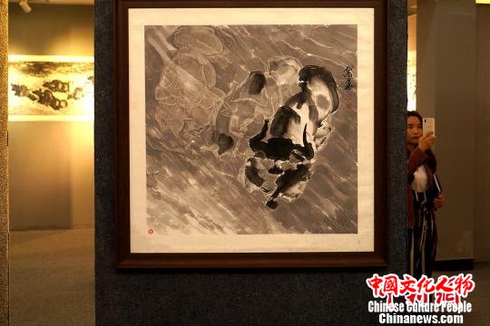 目前，孟繁华的绘画作品在西藏自治区群艺馆内展出。图为参加展览的观众浏览他创作的水墨写意牦牛画作品。　江飞波 摄