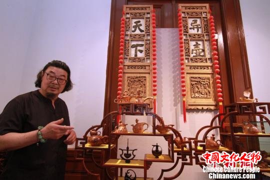 魏氏木雕技艺传承人魏宝全介绍“木雕壶”。　张道正 摄