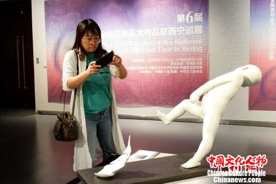 图为雕刻爱好者在展览留影。　李隽 摄