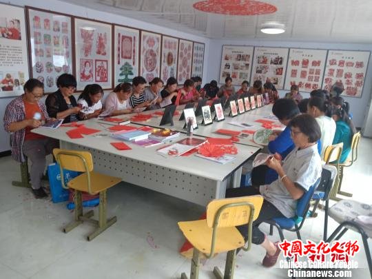 图为村民在非遗扶贫就业工坊练习剪纸 冯维健 摄 图为村民在非遗扶贫就业工坊练习剪纸 冯维健 摄