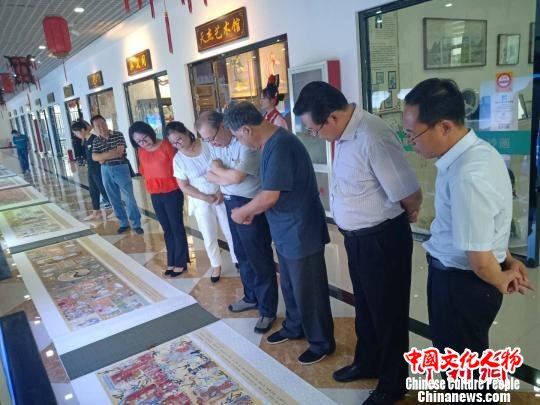 图为张冬阁(右三)向到场嘉宾介绍自己的画作 冯维健 摄 图为张冬阁(右三)向到场嘉宾介绍自己的画作 冯维健 摄